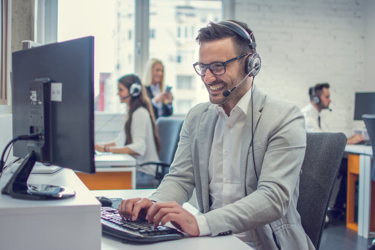 Handsome technical support agent using desktop computer in office.